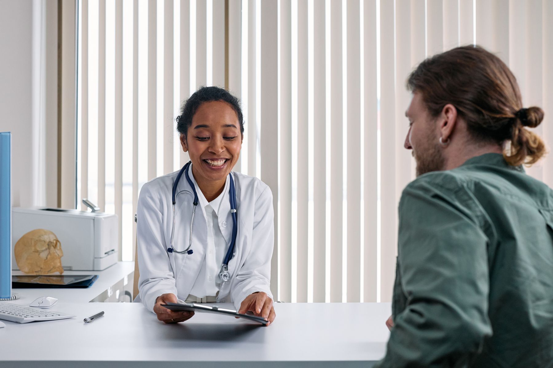 Doctor and adult patient talking in a bright consultation room